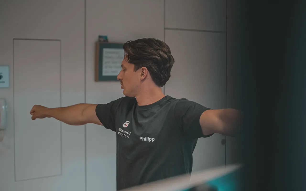 Philipp Schmitt streckt im Trainingsraum die Arme zur Seite aus