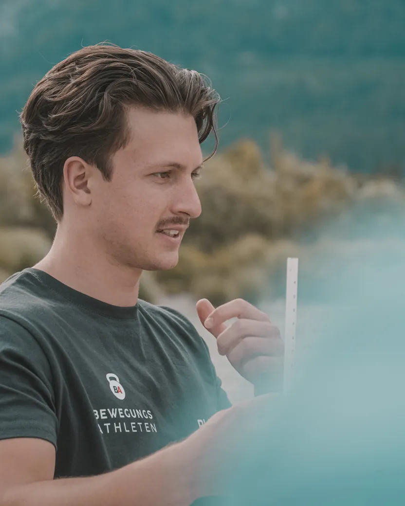 Philipp Schmitt mit einem Trainingsstab am Flussufer