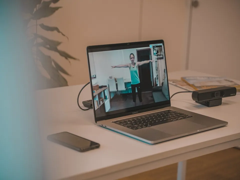 Laptop mit laufendem Online-Coaching: eine Kundin trainiert per Videocall