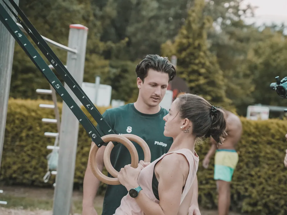 Philipp Schmitt gibt einer Kundin Hilfestellung beim Ringtraining