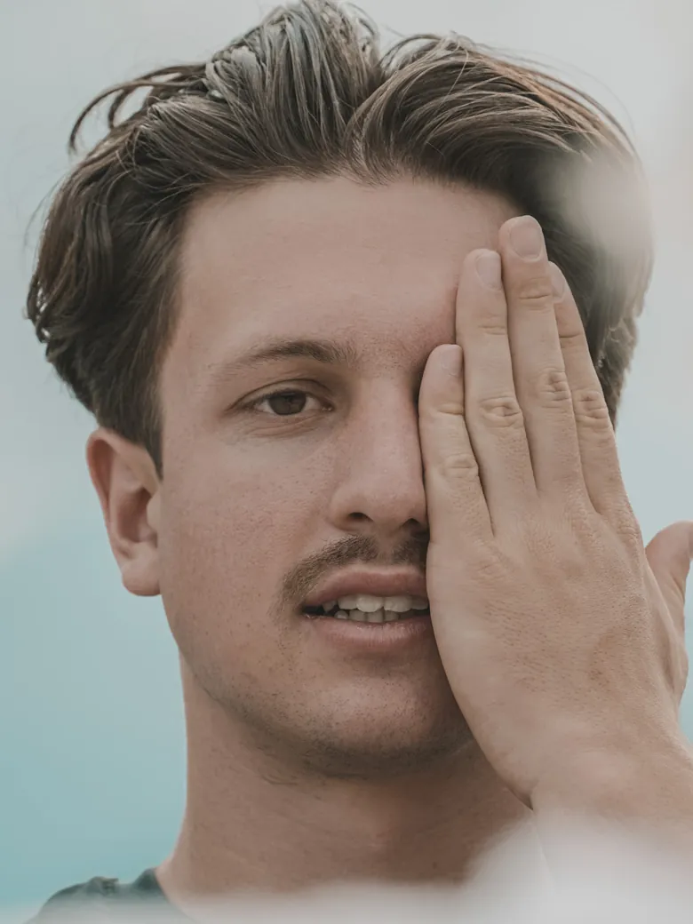 Philipp Schmitt hält sich beim Sehtraining ein Auge zu