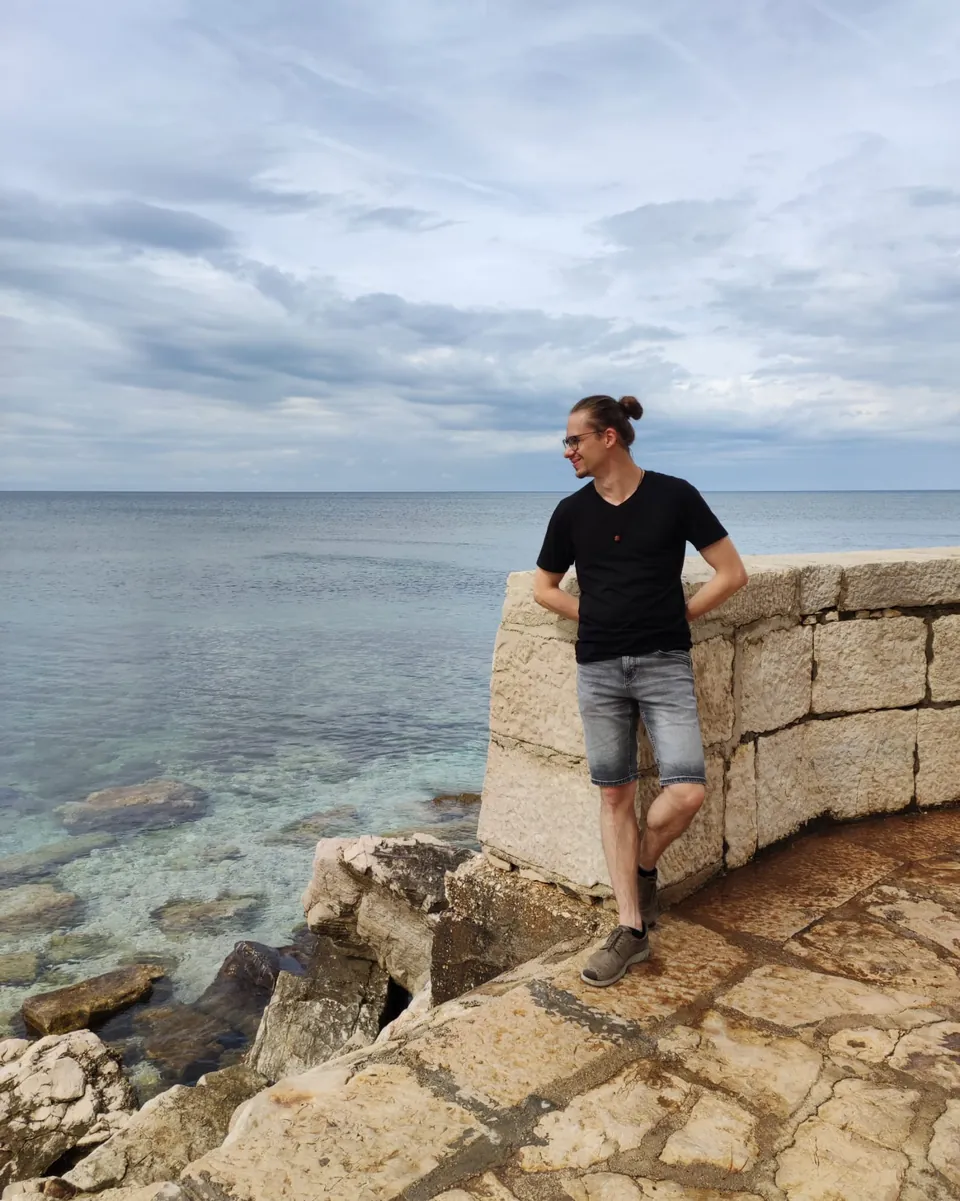 Max an einer Steinmauer am Meer