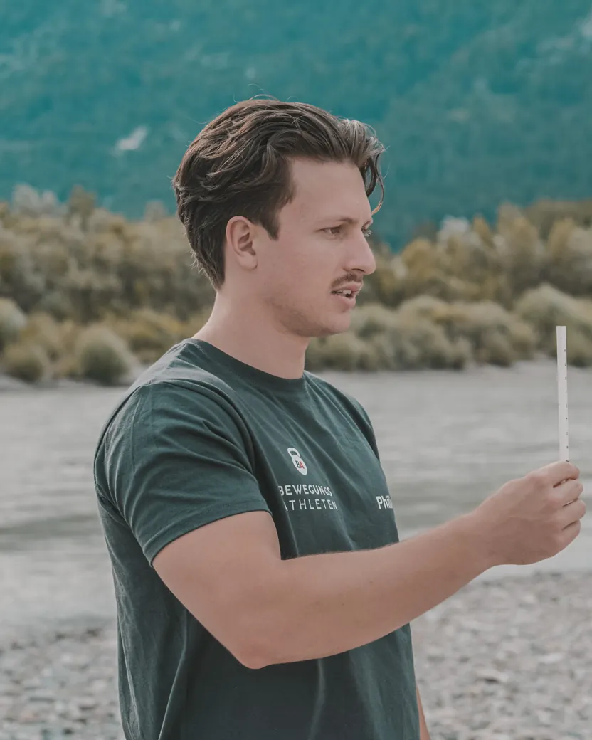 Philipp Schmitt erklärt einer Kundin am Flussufer eine Übung