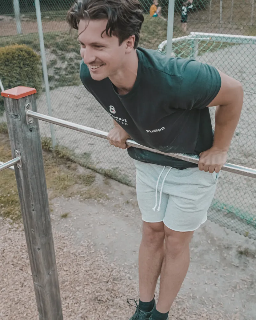 Philipp Schmitt lacht beim Training an der Stange im Calisthenics-Park